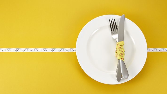 Knife and fork wrapped in tape measure on a plate | CFHP